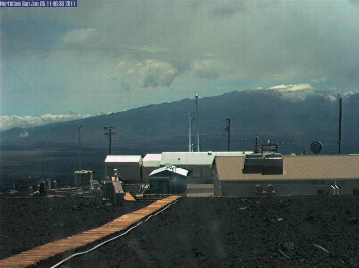 Esta imagen muestra la cumbre nevada del Mauna Kea el 5 de junio 2011 visible en la parte superior derecha del Observatorio de CO2 del Mauna Loa.